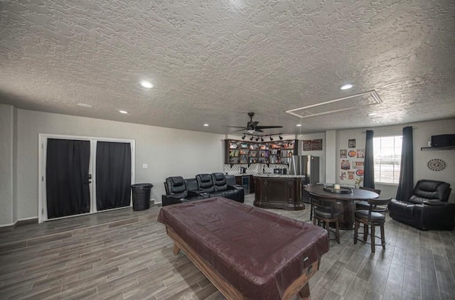 recreation room with a community bar, billiards, attic access, and wood finished floors