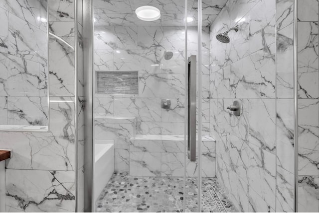 bathroom featuring a marble finish shower