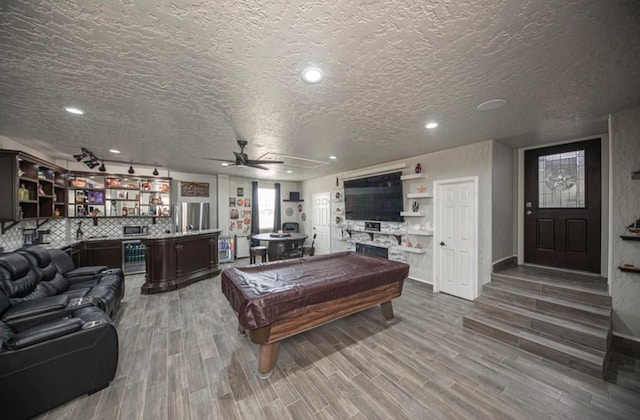 recreation room featuring pool table, bar, ceiling fan, and wood finished floors