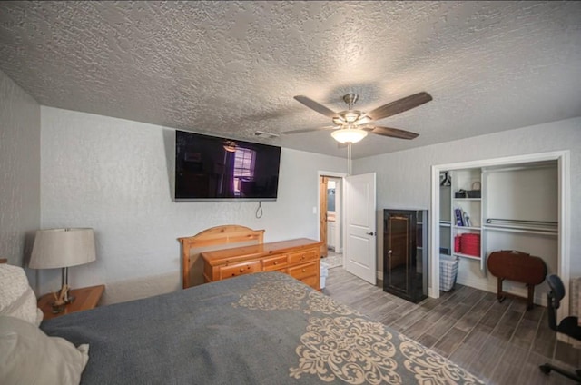 bedroom featuring a textured ceiling, a ceiling fan, and wood finished floors