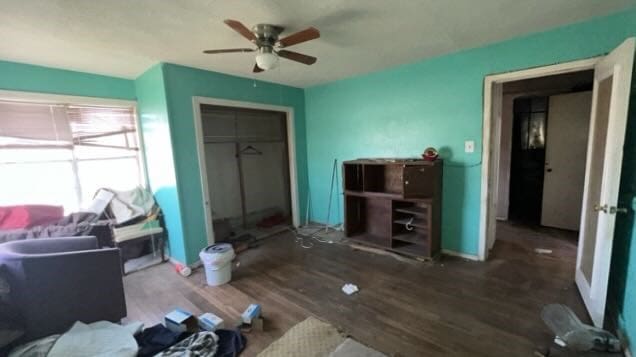 bedroom with a closet, baseboards, ceiling fan, and wood finished floors