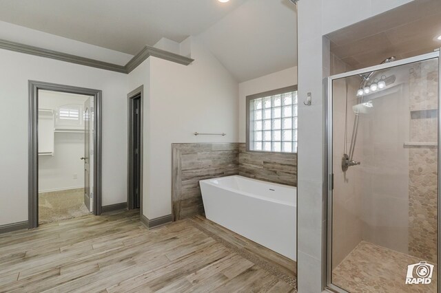 7011 Willowbend St, Odessa, TX 79762 - full bath featuring a shower stall, a freestanding bath, wood finished floors, lofted ceiling, and baseboards