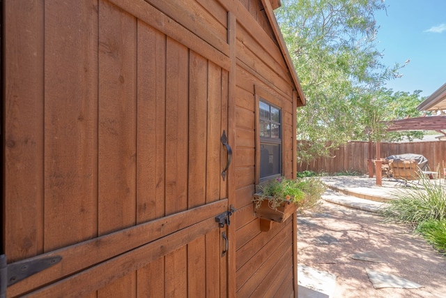 exterior space with board and batten siding, a patio area, and fence