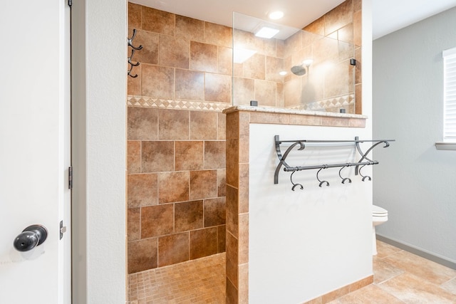 bathroom featuring baseboards, walk in shower, toilet, and tile patterned floors