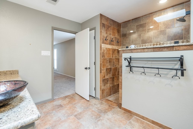 full bath with visible vents, walk in shower, vanity, and baseboards