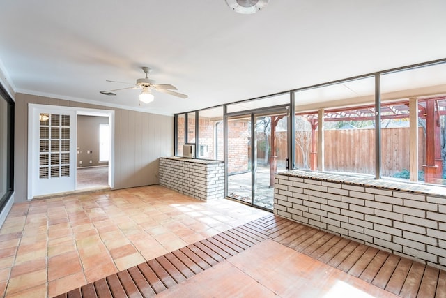 unfurnished sunroom with ceiling fan