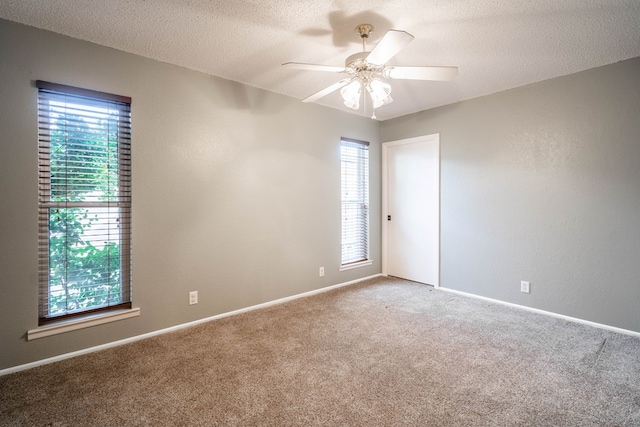 unfurnished room with a healthy amount of sunlight, ceiling fan, and a textured ceiling