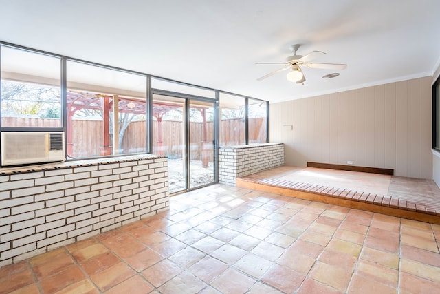 empty room with a sunroom, crown molding, cooling unit, and a ceiling fan