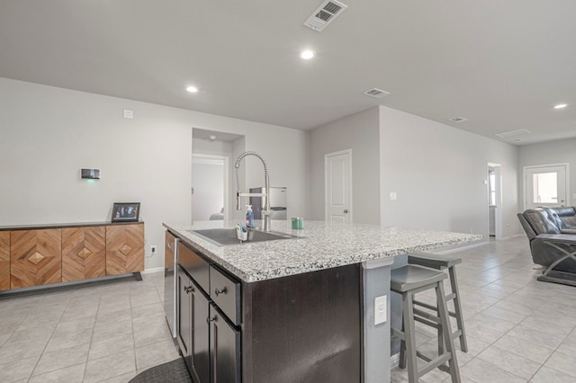 kitchen featuring open floor plan, visible vents, a sink, and an island with sink