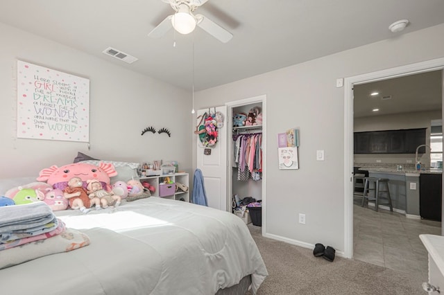 bedroom featuring light carpet, baseboards, visible vents, a ceiling fan, and a closet