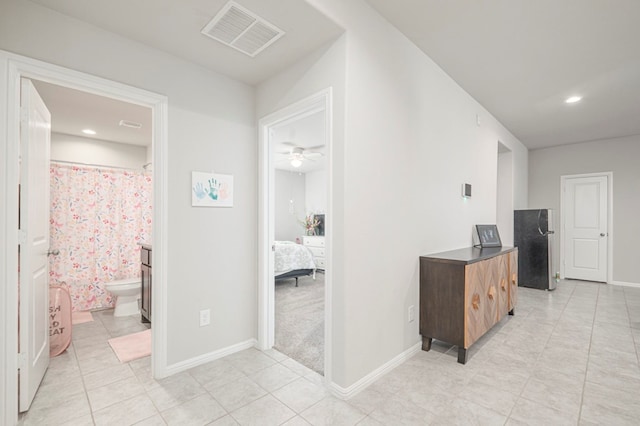 hallway featuring light tile patterned floors, recessed lighting, visible vents, and baseboards