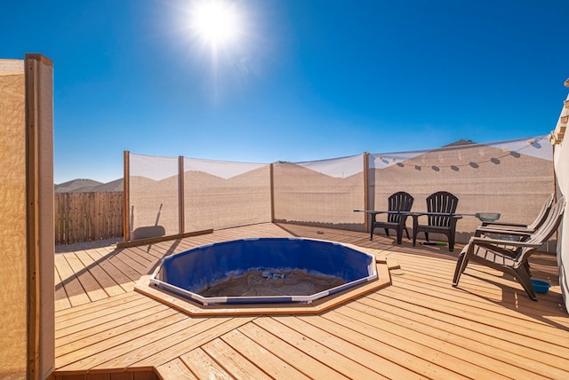 view of pool featuring fence and a deck with mountain view