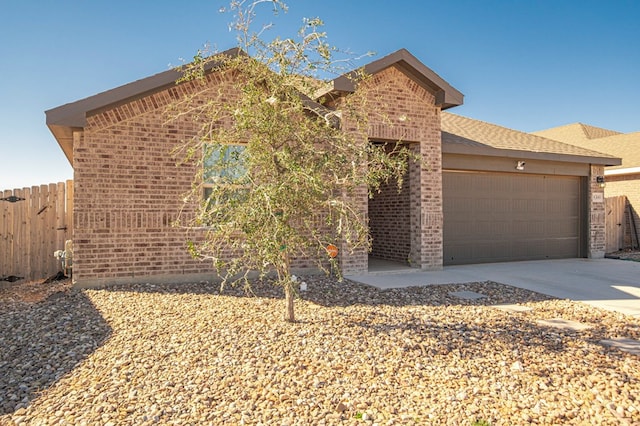 ranch-style home with an attached garage, fence, concrete driveway, and brick siding