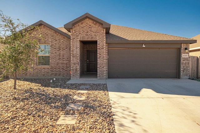 ranch-style home featuring an attached garage, roof with shingles, concrete driveway, and brick siding