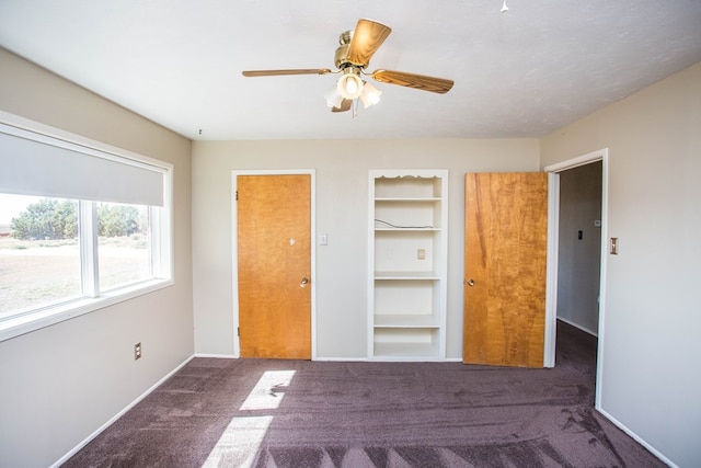 unfurnished bedroom featuring dark colored carpet, ceiling fan, and a closet