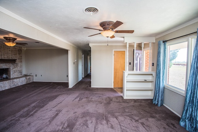 unfurnished living room featuring a fireplace, dark carpet, crown molding, and ceiling fan