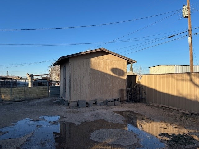 view of outbuilding featuring fence