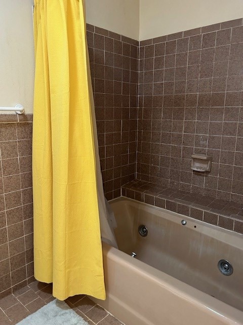full bathroom with tile patterned flooring, shower / bath combo with shower curtain, and tile walls