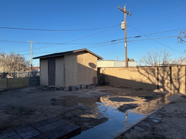 exterior space featuring an outdoor structure, a fenced backyard, and a shed