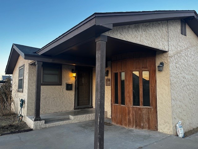 property entrance with stucco siding
