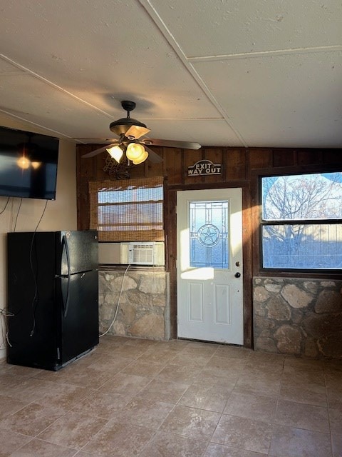 entrance foyer with cooling unit, wooden walls, and a ceiling fan