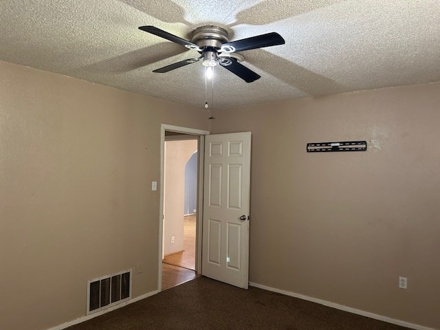 unfurnished room with visible vents, baseboards, ceiling fan, carpet flooring, and a textured ceiling