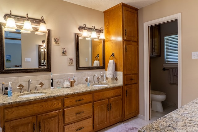 full bathroom featuring a sink, tile patterned floors, toilet, and double vanity