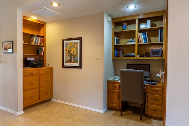 office with light tile patterned flooring, a textured ceiling, built in features, baseboards, and visible vents