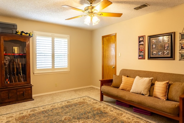 carpeted living area featuring visible vents, a ceiling fan, a textured ceiling, and baseboards