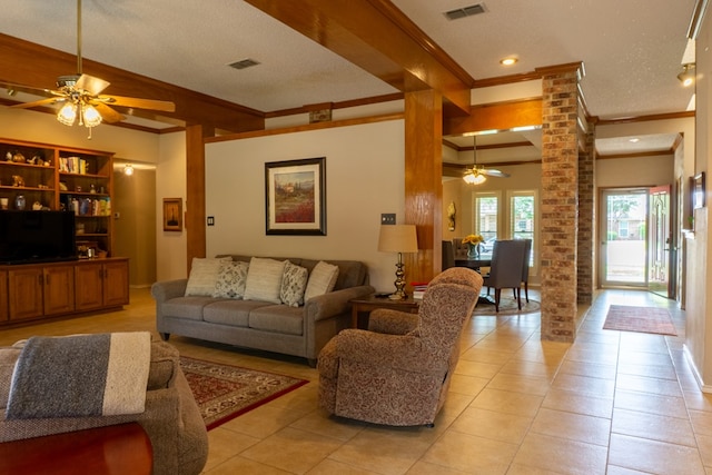 living area with a ceiling fan, visible vents, crown molding, light tile patterned floors, and ornate columns