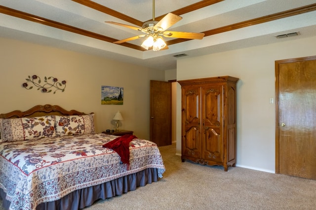 bedroom featuring ceiling fan, visible vents, a tray ceiling, and carpet