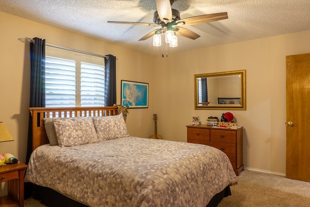 bedroom featuring light colored carpet, a textured ceiling, and ceiling fan