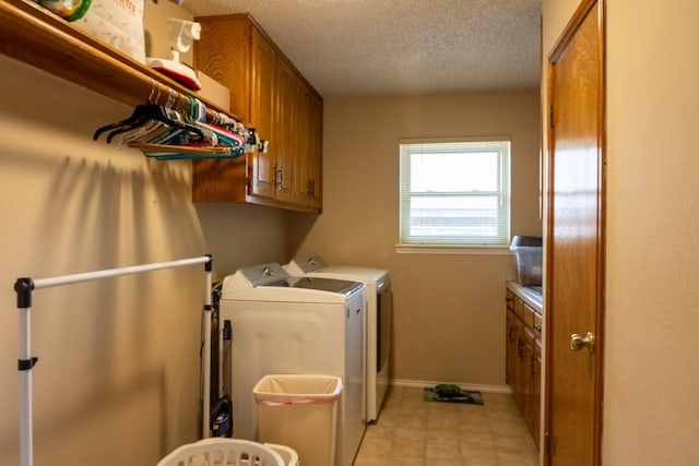 laundry area with a textured ceiling, washing machine and clothes dryer, cabinet space, baseboards, and light tile patterned flooring