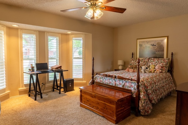carpeted bedroom featuring baseboards, a ceiling fan, and a textured ceiling