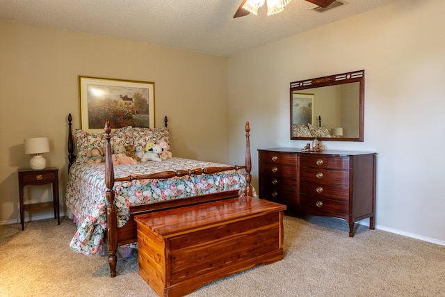 carpeted bedroom with visible vents, a ceiling fan, baseboards, and a textured ceiling