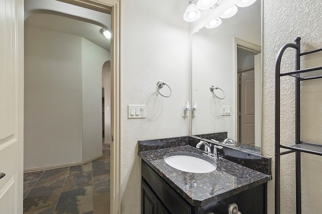bathroom featuring stone tile floors and vanity