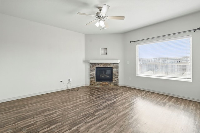 unfurnished living room with a fireplace, wood finished floors, a ceiling fan, and baseboards