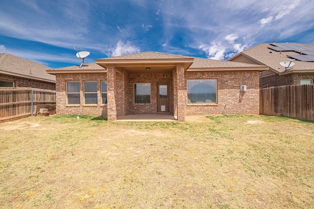 rear view of house featuring brick siding, a patio area, and a shingled roof