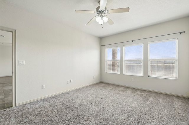 unfurnished room with carpet flooring, ceiling fan, and baseboards