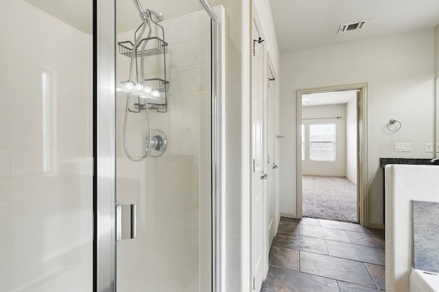 bathroom featuring a shower stall and stone tile flooring