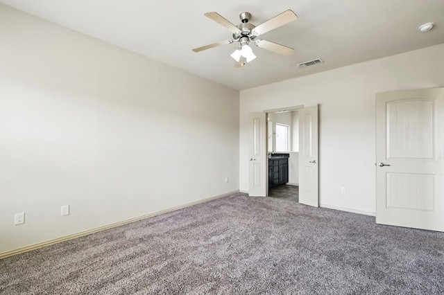 unfurnished bedroom featuring carpet floors, baseboards, connected bathroom, and a ceiling fan