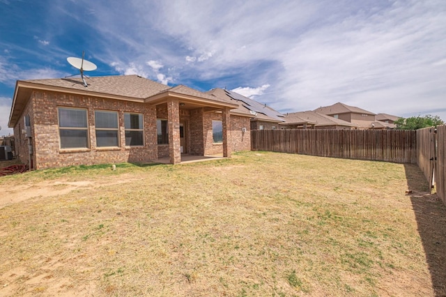 back of property with brick siding, a patio area, central AC unit, and roof with shingles