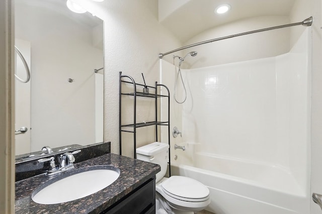 bathroom with toilet, shower / bath combination, vanity, and a textured wall