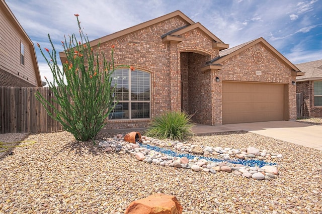 view of front of property with brick siding, fence, a garage, and concrete driveway
