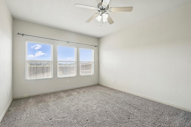 carpeted spare room with baseboards and ceiling fan