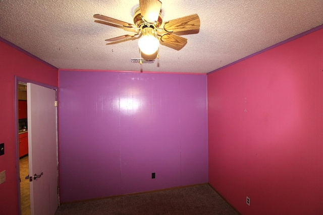 carpeted empty room with visible vents, ceiling fan, and a textured ceiling