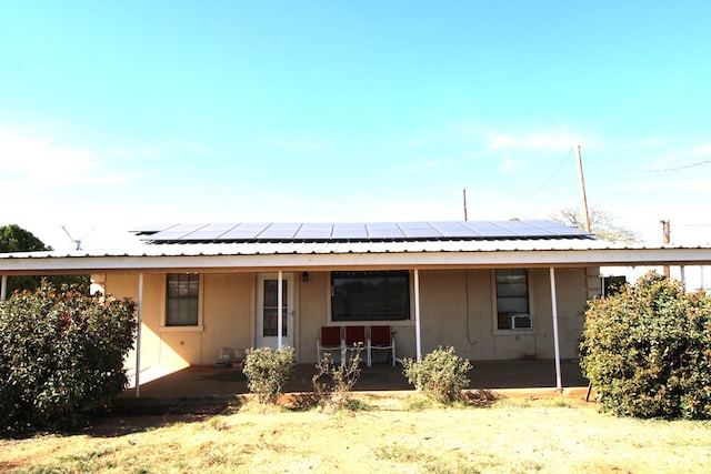 back of property featuring solar panels, a patio, metal roof, and cooling unit