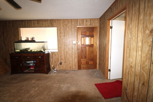 hallway with wood walls and carpet floors