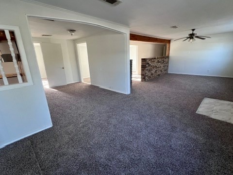 carpeted empty room with crown molding and ceiling fan