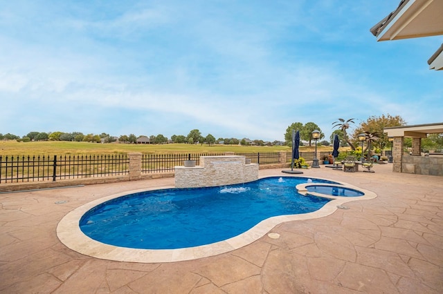 view of pool featuring a rural view, a patio, and an in ground hot tub